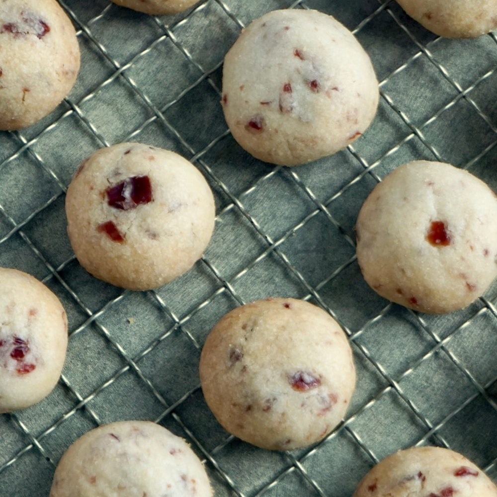 Baked cookies with red berries on a cooling rack