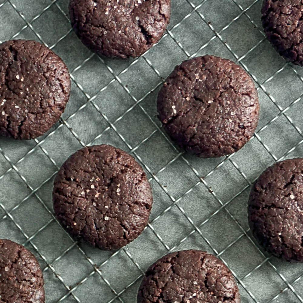 Chocolate cookies with some sea salt on the cookies, on a cooling rack